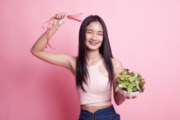 Healthy  Asian woman with measuring tape and salad.