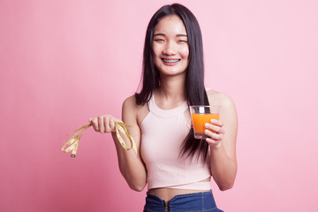 Asian woman drink orange juice hold measuring tape.