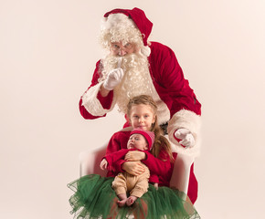 Christmas portrait of cute little newborn baby girl, dressed in christmas clothes, studio shot, winter time