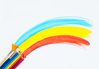 Obraz premium brush for painting or drawing and a rainbow on a white background, the idea of creativity or finishing works. minimalism.