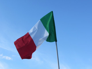 National flag of Italy waving against blue sky