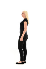 full length portrait of blonde girl wearing black clothing, isolated on white background.