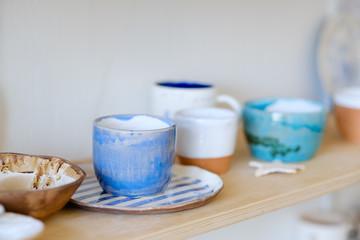 pottery handcraft hobby. assortment of handmade clay plates jugs mugs and cups