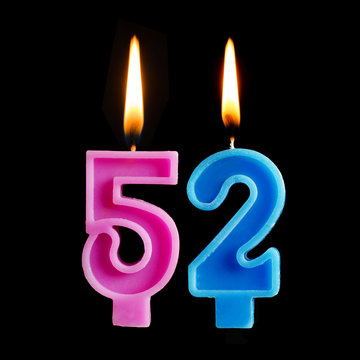 Burning birthday candles in the form of 52 fifty two for cake isolated on black background.