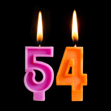 Burning birthday candles in the form of 54 fifty four for cake isolated on black background.