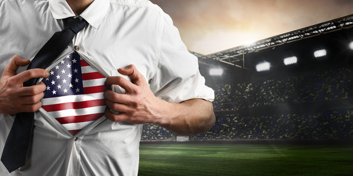 USA soccer or football supporter showing flag under his business shirt on stadium.