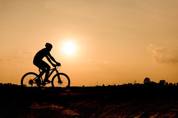 Fototapeta na wymiar Silhouette of cycling on sunset background.