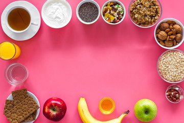 Fototapeta na wymiar Ideas of healthy hearty breakfast for sportsmen. Fruits, oatmeal, yogurt, nuts, crispbreads, chia on pink background top view copy space