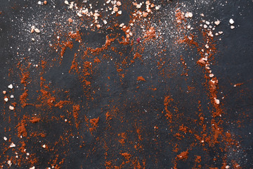 food preparing and cooking. spices mix on dark background. chunks of salt and red pepper or paprika...