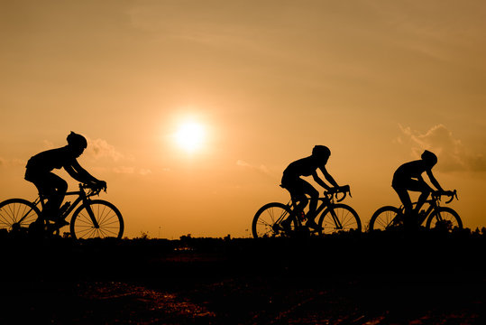 Silhouette of cycling on sunset background.