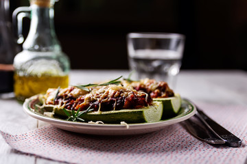 Stuffed zucchini on a green plate on the table