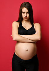 Young pregnant happy mother woman angry looking at the corner on red 