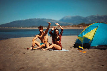 Young happy couple camping on the beach during the summer