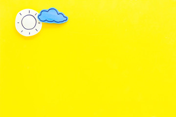 Clear and cloudly weather icons on yellow background top view copy space