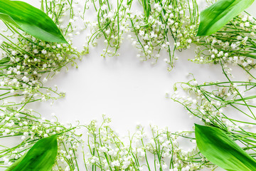 Lily of the valley flowers frame. Spring background on white desk top view copy space