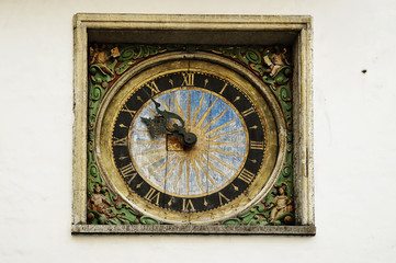 Fototapeta na wymiar old clock on the wall of the church in the old town