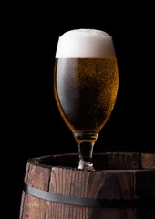 Rolgordijnen Bier Cold glass of craft beer on old wooden barrel
