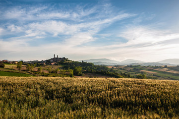 Italia, Pesaro Giugno 2018. Bellissima vista del borgo medievale di Orciano nella regione Mrche con i campi di grano e le magnifiche colline
