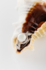 Silver ring with big pearl and diamonds on seashell