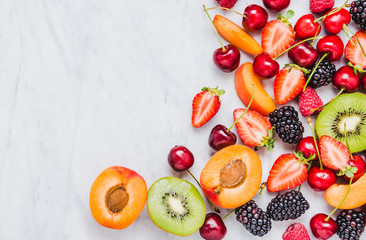 Fruits, berries on white marble table copy space flat lay.