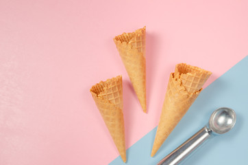Ice cream waffle cones over sweet pink and light blue background with scoop and copy space for text, logo or wordings insertion or decoration, summer cold sweets