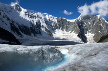Fototapeta na wymiar Arbuz glacier with melt water stream against mountains. Altai, Russia