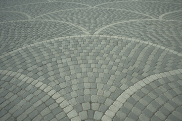 Fototapeta premium Sidewalk tile laid out from sea pebble stones in a beautiful mosaic pattern. Cobblestone pavement.
