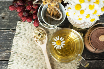 cup of herbal chamomile tea with fresh daisy flowers on wooden background. doctor treatment and prevention of immune concept, medicine - folk, alternative, complementary, traditional medicine 