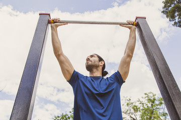 Young man making Pull-up strength training exercise