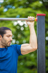 Fototapeta premium Young man making Pull-up strength training exercise