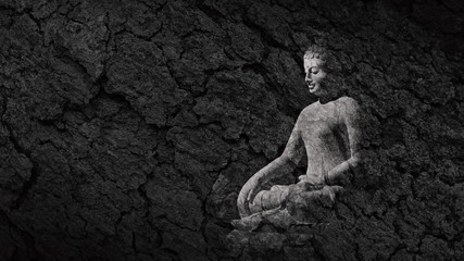 buddha statue on a teak bark texture - abstract monochrome background