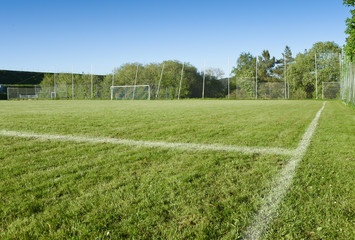 Im Sommer auf einem leeren Fußballplatz. Der Rasenplatz hat aufgebrachte Linien zur Begrenzung des...