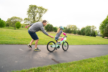 Father teaches daughter to ride a bike