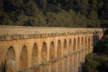 Obraz premium Ancient viaduct bridge from the bottom view in the setting sun