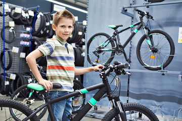 Obraz premium Boy and bicycle in sport store