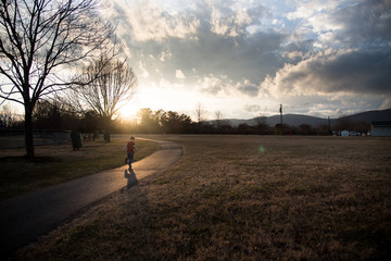 Child Running in Evening Light with Sunset