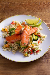 Salmon with tomato couscous, zucchini and lime