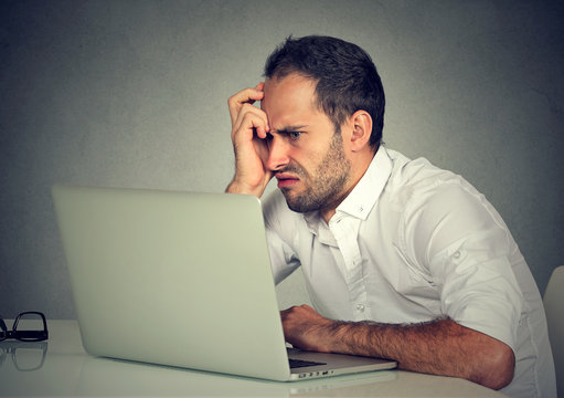 Negative man using laptop in anger