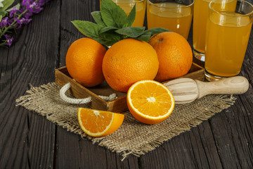 Fototapeta na wymiar Fresh orange juice with mint in a glass bowl on a dark plate. Orange juice on a dark background, top view, copy space.