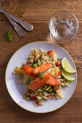 Salmon with tomato couscous, zucchini and lime. View from above, top studio shot