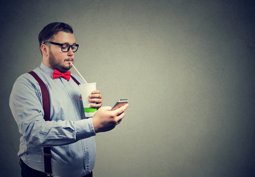 Obese man with soda and phone