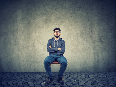 Pensive hipster man on chair