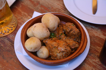 Wrinkled potatoes called papas arrugadas with spicy mojo sauce and rabbit, typical food from the Canary Islands, Spain.