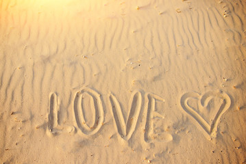 big text LOVE in the sand of the beach