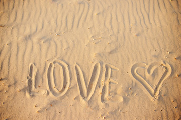 big text LOVE in the sand of the beach