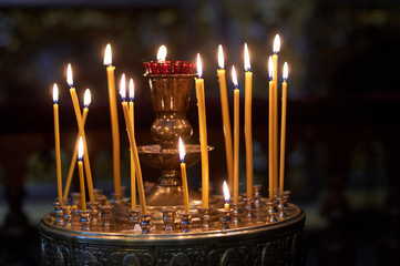 Church candle burns on the altar in front of the Orthodox icon