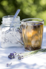 Herbal lavender tea in glass cup with lavender flowers