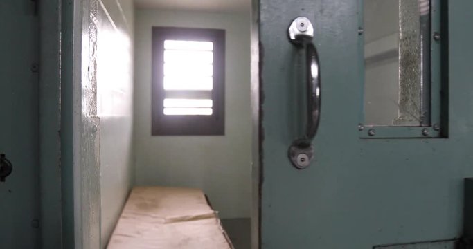 Door of solitary confinement cell opening in old prison.