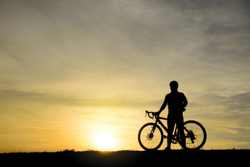 Silhouette of handsome man lift up bicycle on your head on sunset,sport man concept