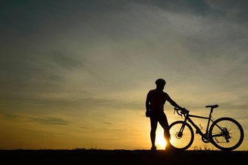 Silhouette of handsome man lift up bicycle on your head on sunset,sport man concept